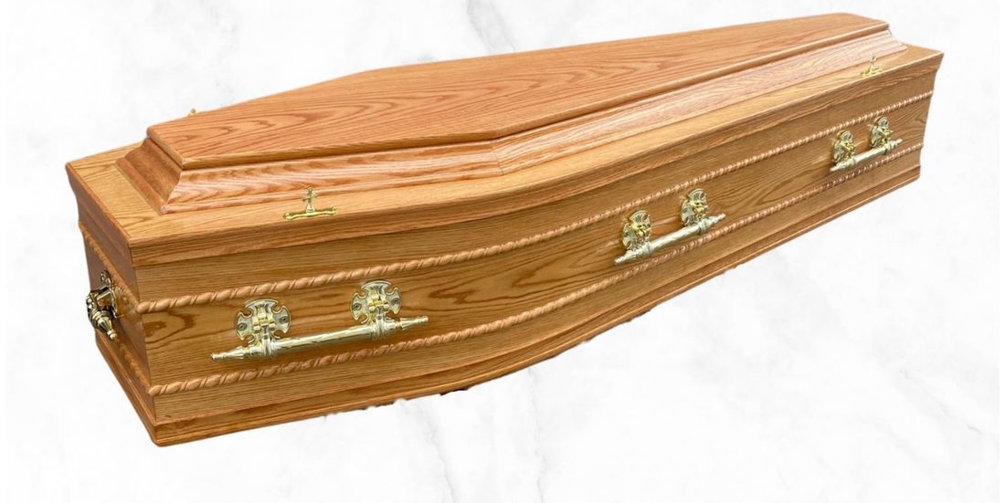 The Clonmore veneer oak coffin with raised lid, beaded panel finish and brass handles